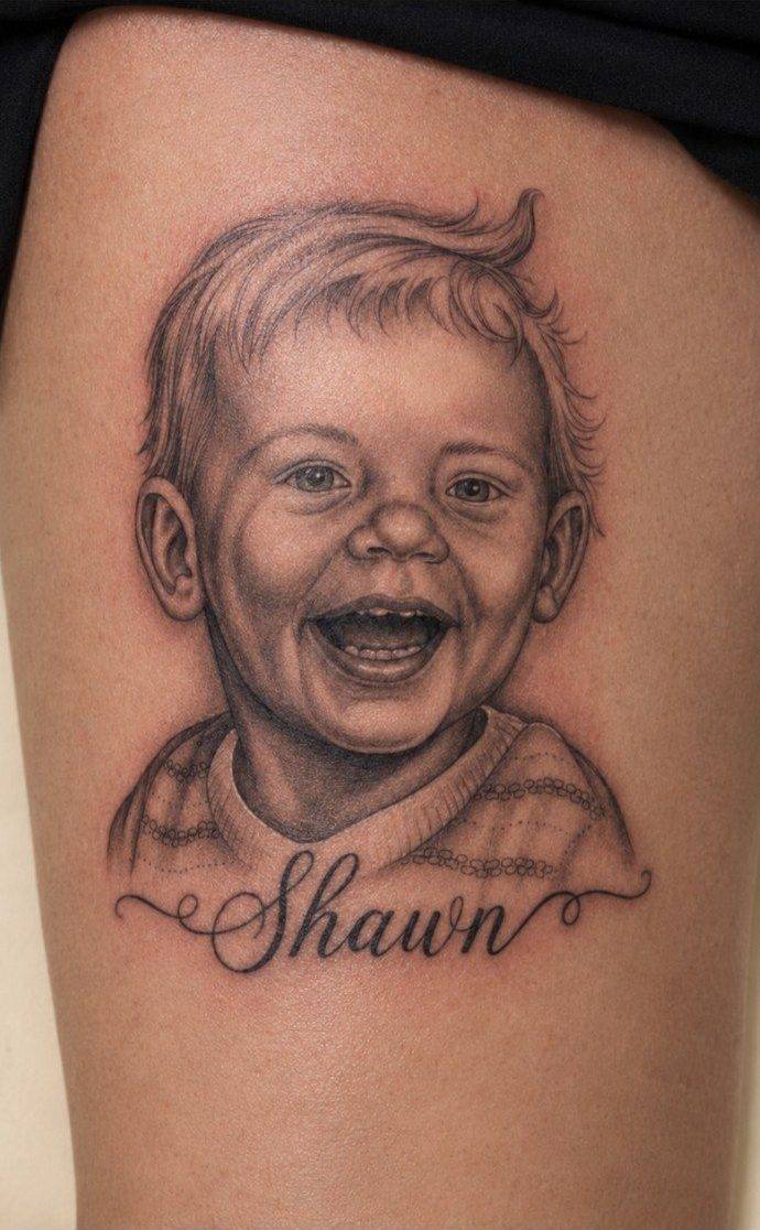 Finished black and grey child portrait tattoo with Shawn script lettering by Fargo Tattoo